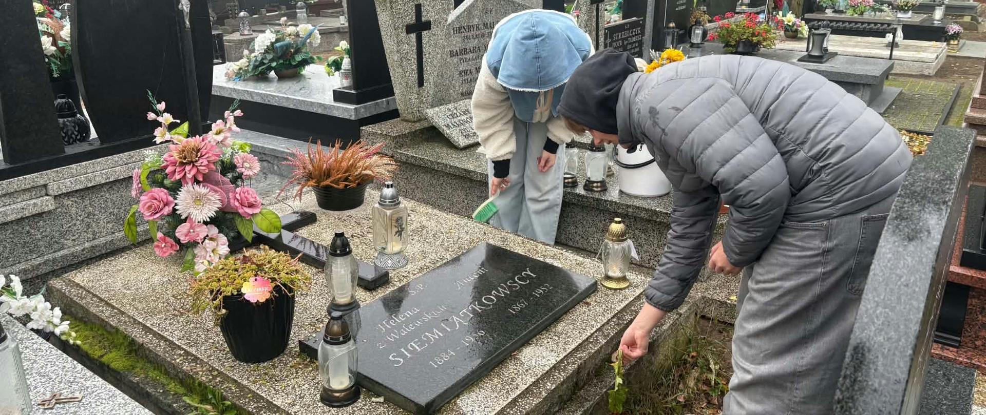 UCZNIOWIE PORZĄDKUJĄCY GROBY