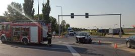 Strażak zabezpiecza rozbity pojazd osobowy na skrzyżowaniu drogi krajowej nr 11 i drogi wojewódzkiej nr 432
