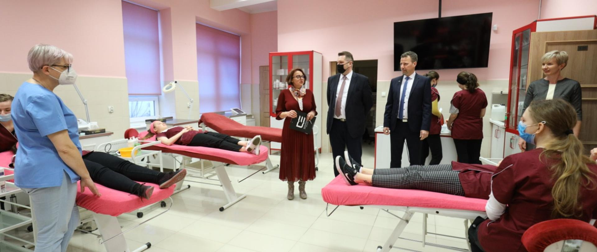 Minister ogląda salę z łóżkami dla pacjentów.