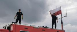  Zespół łączności na dachu samochodu dowodzenia i łączności, flaga Polski powiewa na tle nieba.