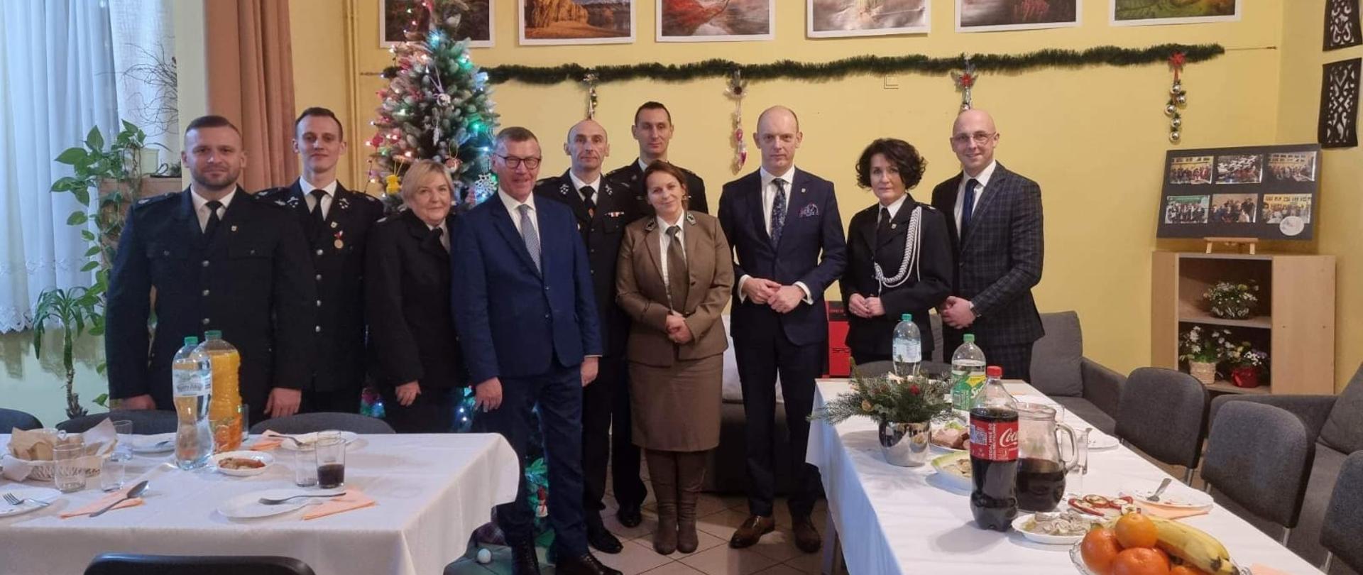 Zdjęcie przedstawia zaproszonych na spotkanie wigilijno-noworoczne gości wraz z gospodarzami.