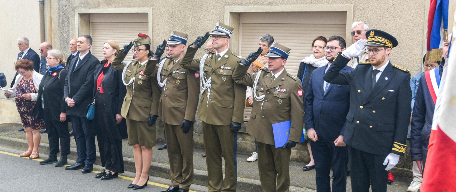 Przedstawiciele władz cywilnych i wojskowych stoją w szeregu.