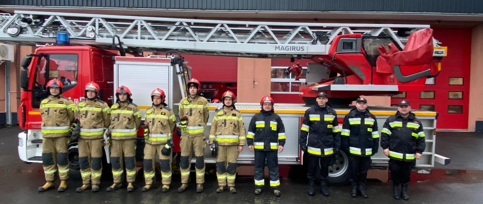 Zdjęcie przedstawia Strażaków PSP na tle drabiny pożarniczej 