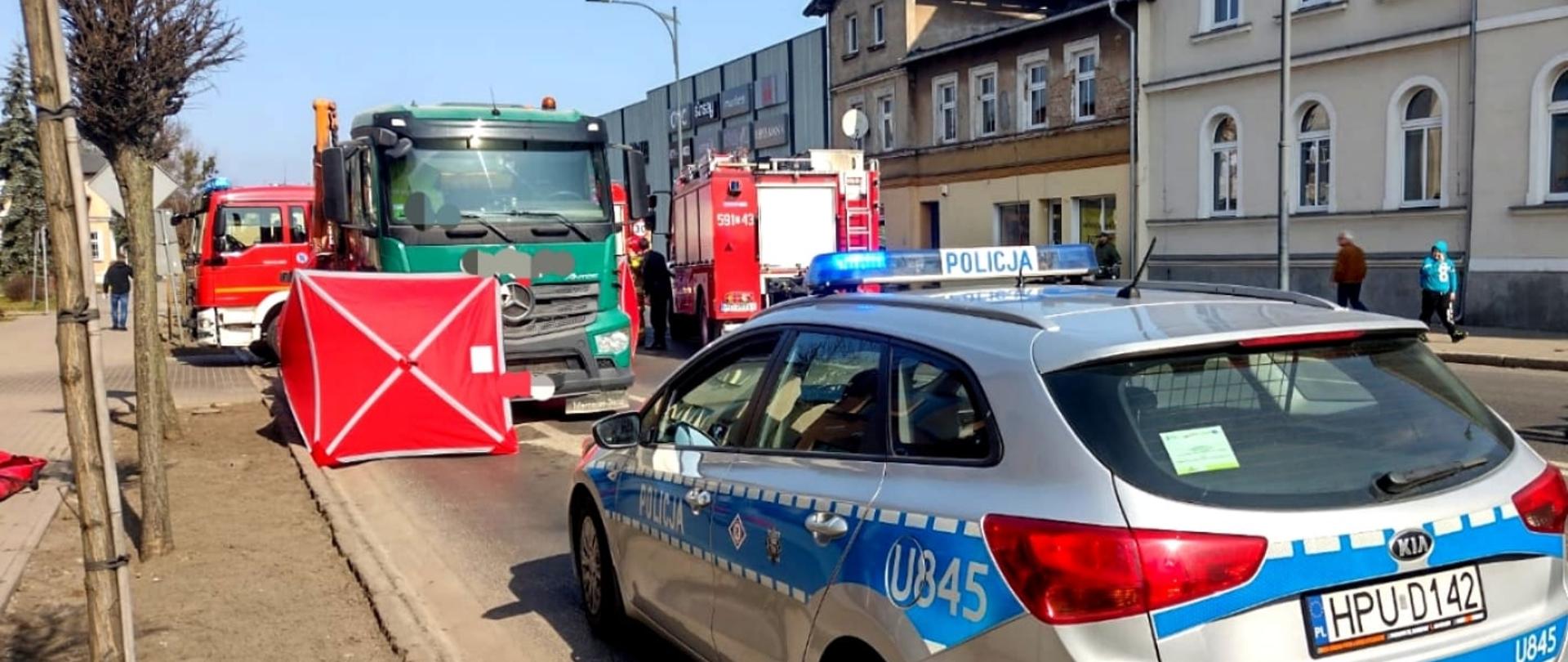 Widać samochód Policji, ciężarowy oraz pojazdy strażackie