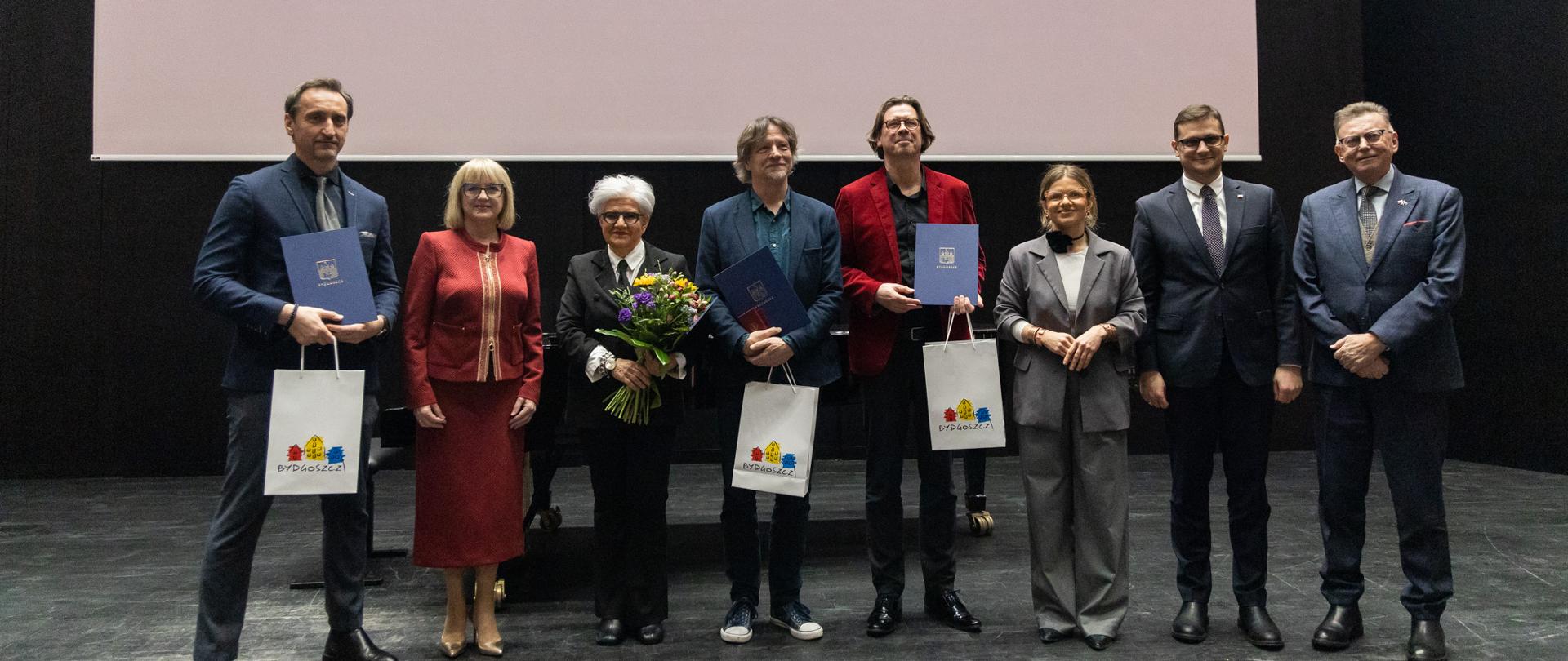 Zbiorowe zdjęcie odznaczonych, którzy stoją na scenie