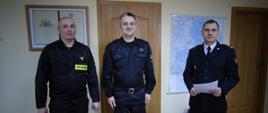 Zdjęcie przedstawia umundurowanych funkcjonariuszy PSP podczas wręczania decyzji o nagrodach jubileuszowych.