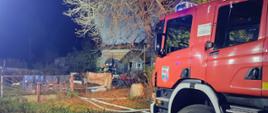 Zdjęcie przedstawia działania ratowniczo-gaśnicze w miejscowości Kaspry. W tel strażacy wchodzący do palącego się budynku.