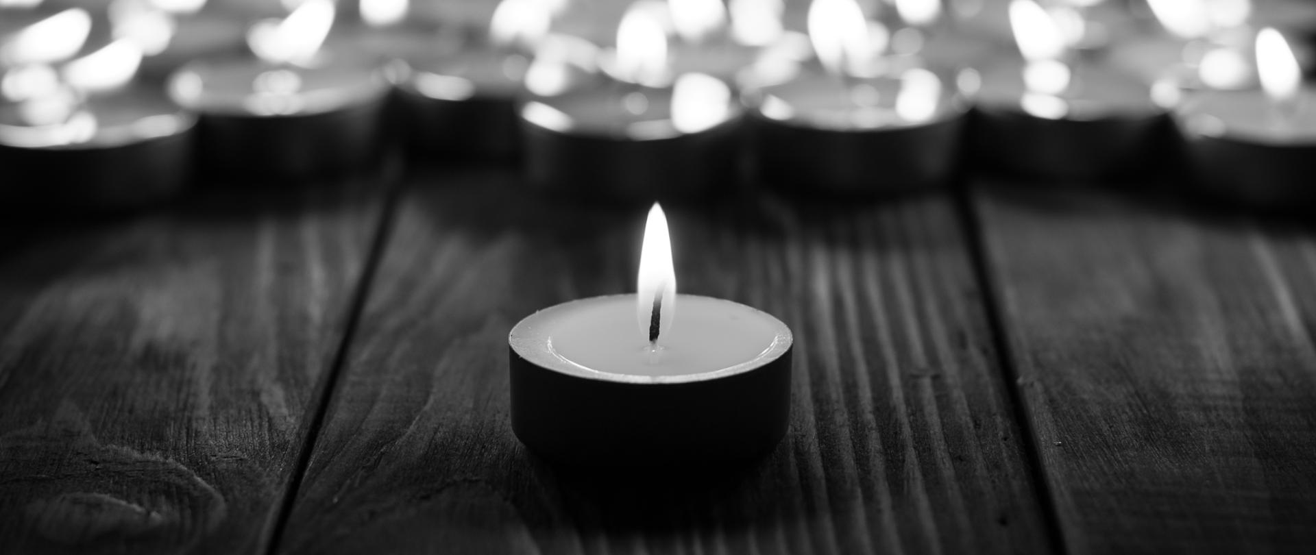 Group of burning candles on black background. Black and white