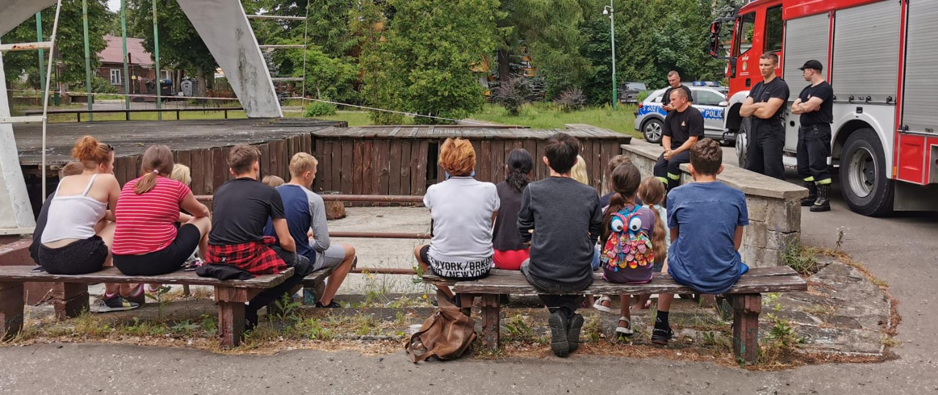 Na zdjęciu widzimy jak skarżyscy strażacy prowadzą pogadankę z zakresu bezpieczeństwa dla dzieci wypoczywających na terenie Ośrodka Wypoczynkowego i Rekreacji „Rejów”. 