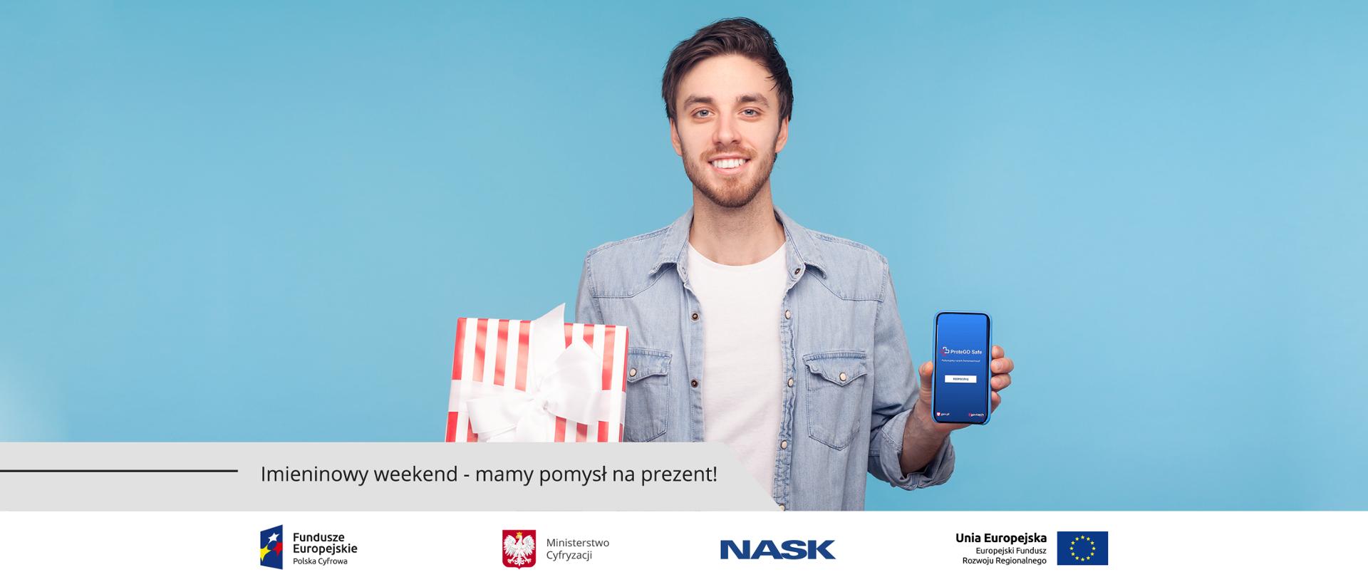 Uśmiechnięty chłopak - w jednej dłoni trzyma zapakowany prezent, w drugiej - smartfona, na ekranie którego widać aplikację ProteGO Safe.