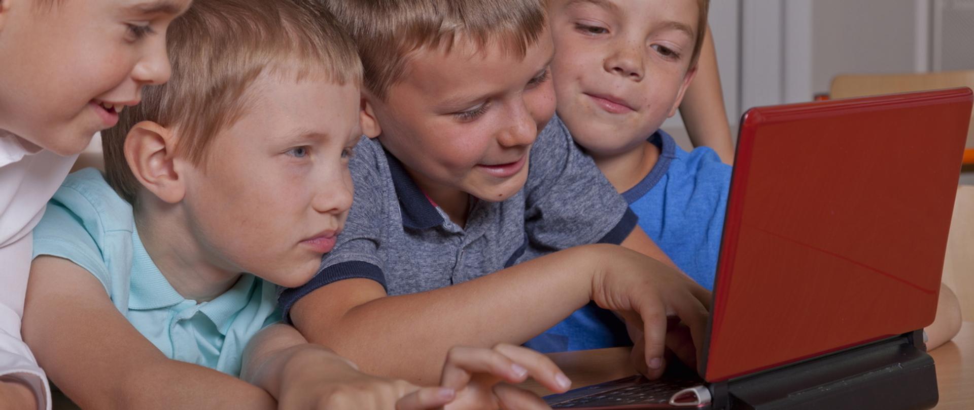 Grupka dzieci przy komputerze.