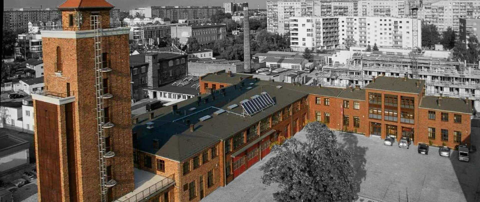 Na zdjęciu budynek Komendy Wojewódzkiej Państwowej Straży Pożarnej we Wrocławiu wykonany z lotu ptaka. W jego tle widoczne okoliczne zabudowania