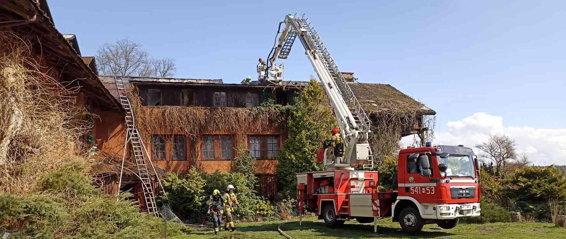 Strażacy gaszący pożar dachu z podnośnika