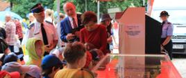 zdjęcie zrobione przed namiotem straży pożarnej pod którym znajdują się symulatory zagrożeń pożarowych. Na zdjęciu widoczny jest Komendant Powiatowy PSP wraz z posłem Janem Mosińskim i minister Marleną Maląg.
