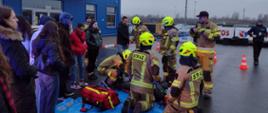 Na zdjęciu strażacy szkolą uczestników szkolenia z zakresu pierwszej pomocy