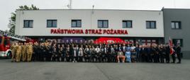 Wspólne zdjęcie uczestników imprezy na tle komendy