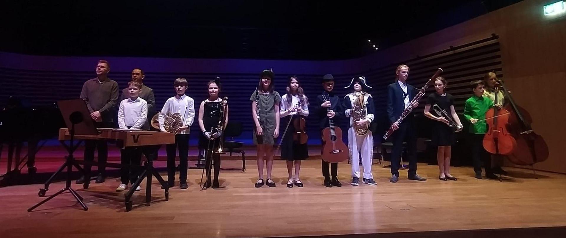 Wszyscy wykonawcy stoją w rzędzie na estradzie.
