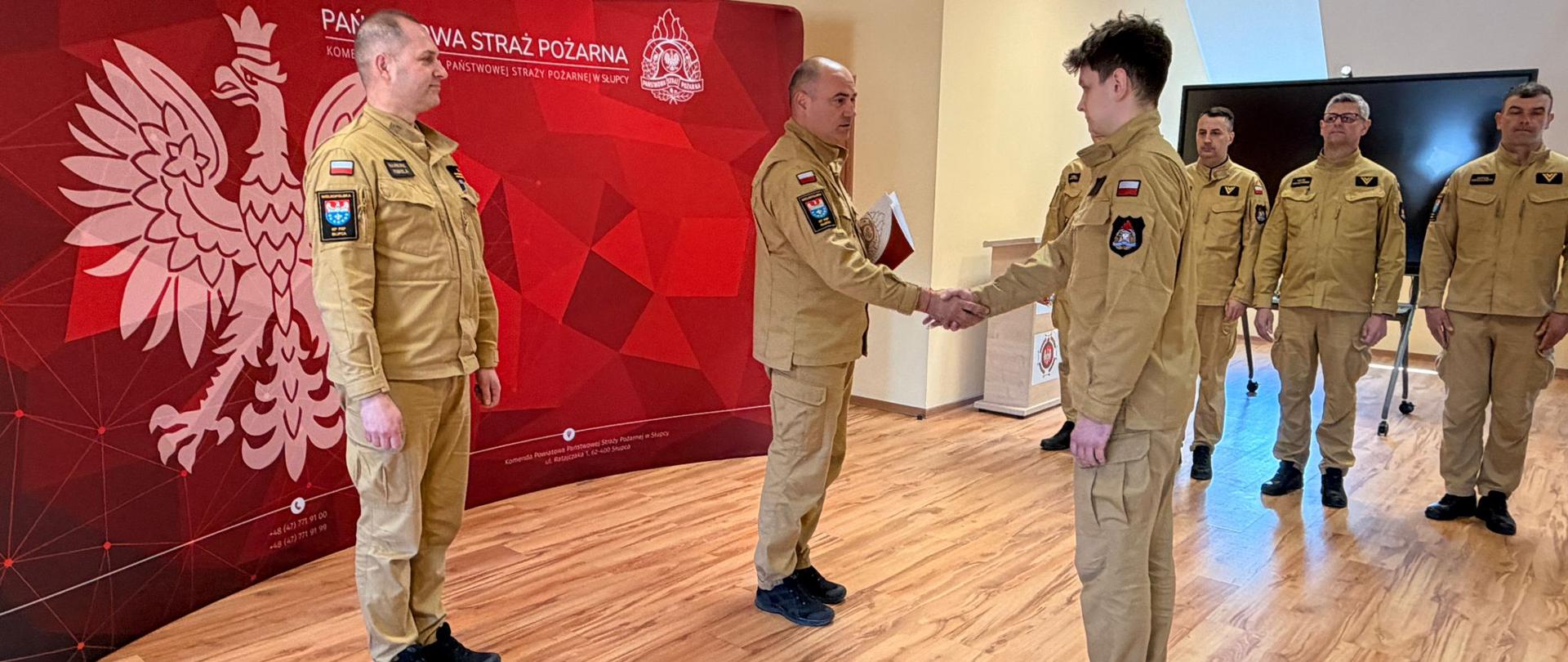 Komendant wręcza strażakowi decyzję