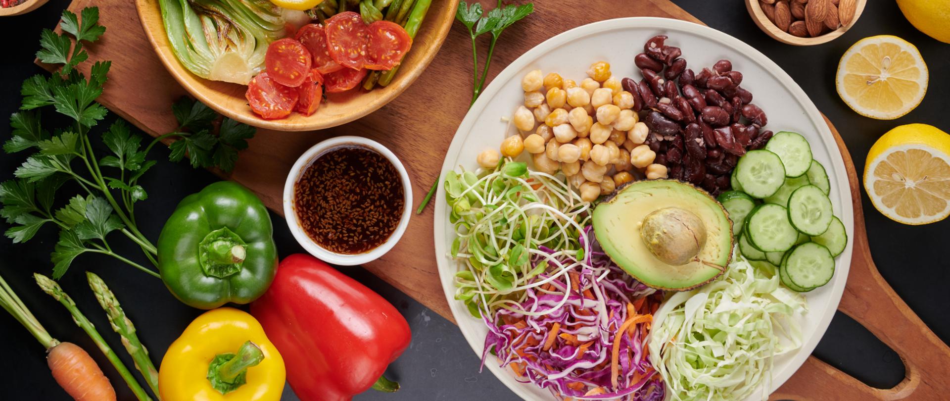 Vegan protein source. Buddha bowl dish, avocado, pepper, tomato, cucumber, red cabbage, chickpea, fresh lettuce salad and walnuts, nuts, beans, . Healthy vegetarian eating, super food. Top view.
