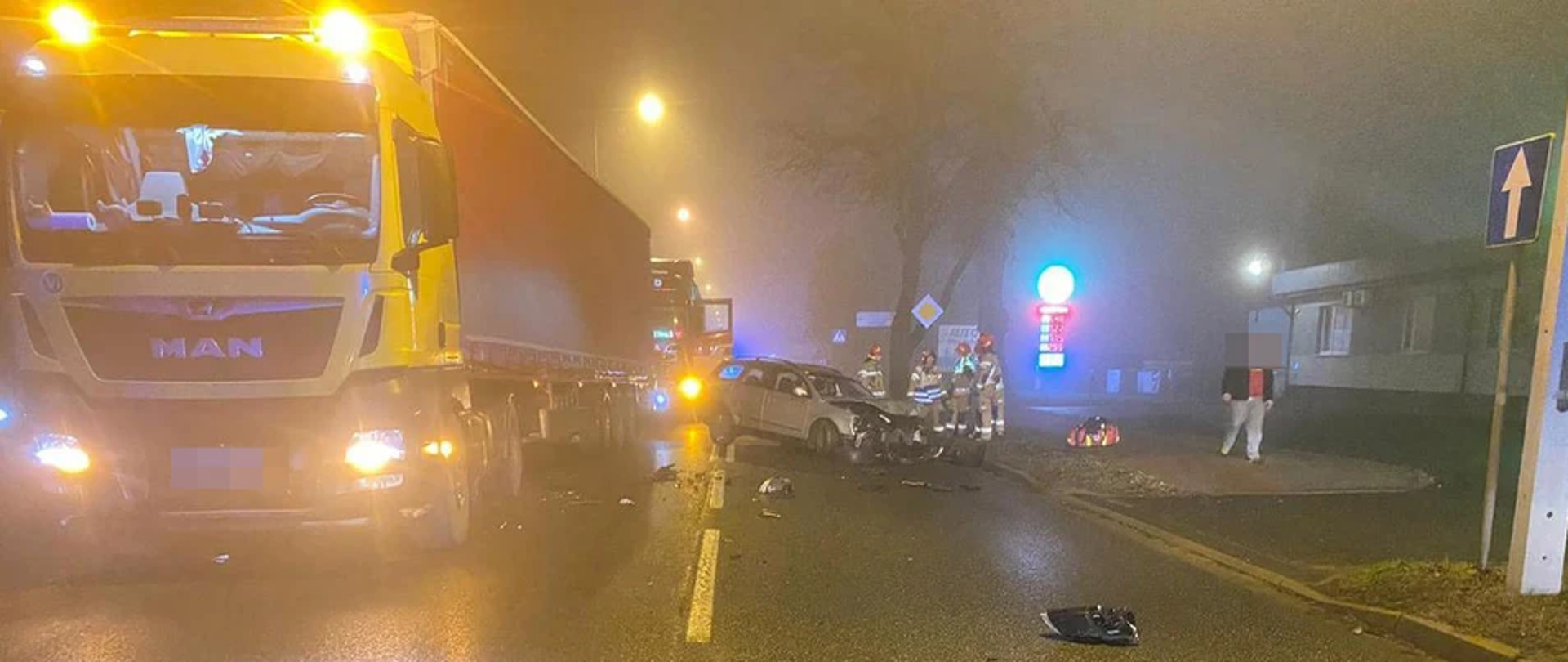 Samochód osobowy po zderzeniu z ciężarowym. Obydwa pojazdu na drodze.