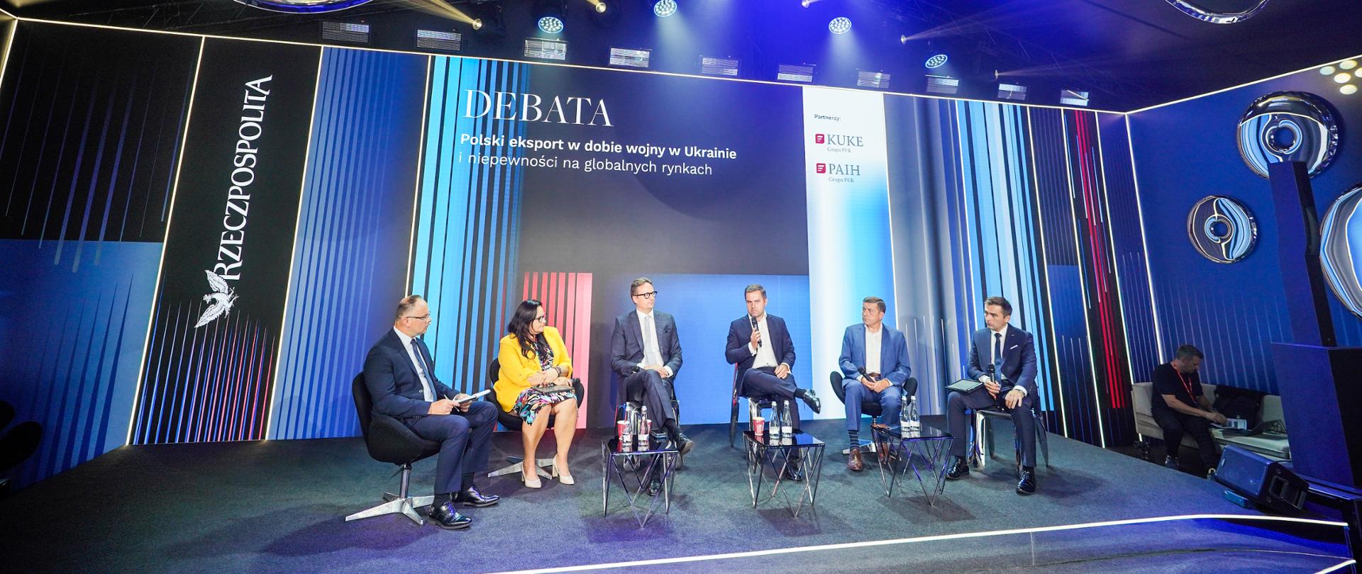 Grupa osób na scenie podczas debaty