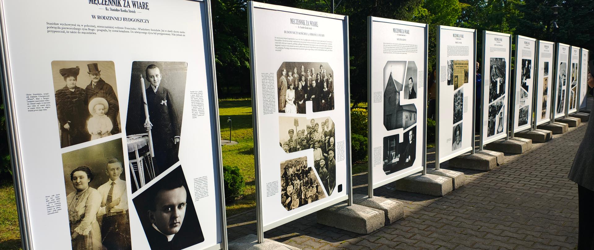 Na zdjęciu znajdują się duże fotoramy ze zdjęciami i biografią ks. Stanisława Streicha. Plansze w liczbie 10 sztuk znajdują się w plenerze, na tle zielonych roślin, ustawione na wybrukowanym chodniku w rzędzie. Na każdej z plansz na górze jest napis MĘCZENNIK ZA WIARĘ Ks. Stanisław Kostka Streich oraz tytuł okresu życia księdza. Zdjęcia na każdej z plansz układają się w literę, a wszystkie tworzą napis KS. STREICH.