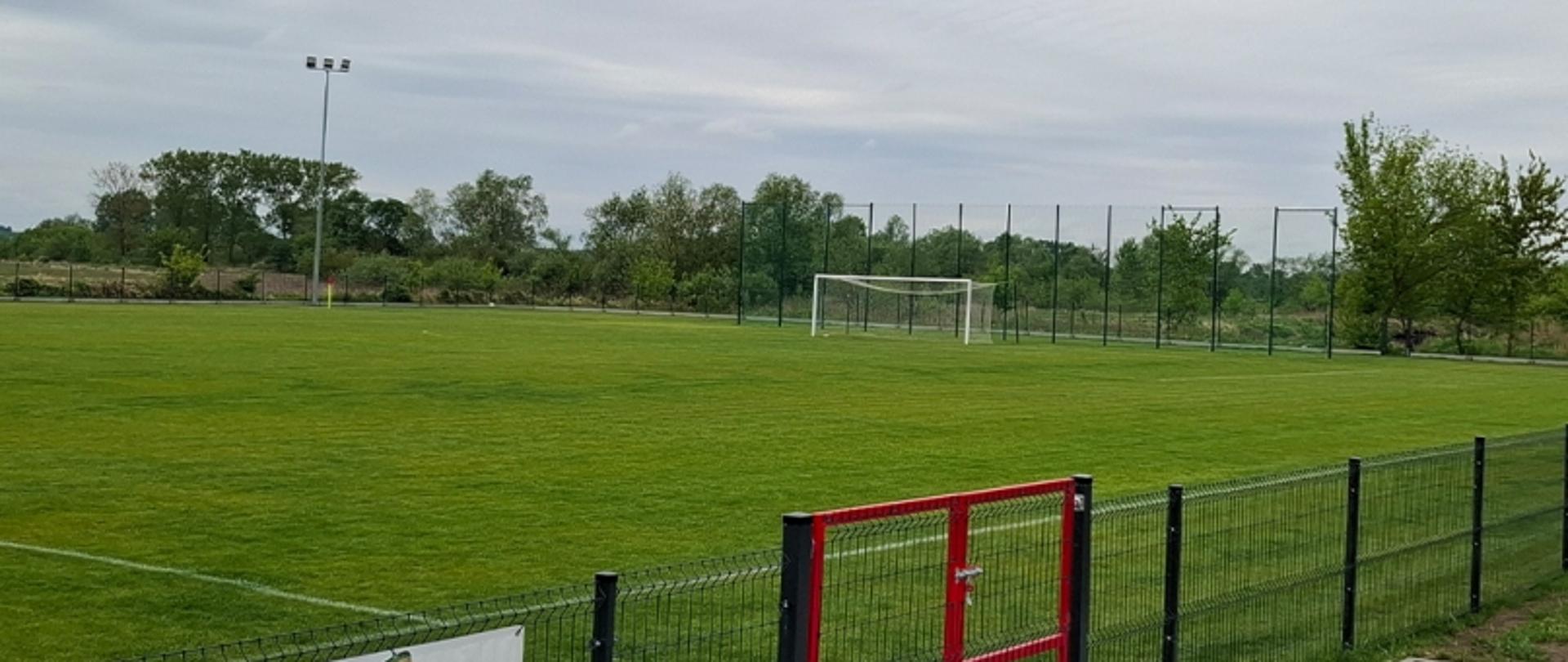 Nowo wybudowany stadion piłkarski z zieloną murawą, ogrodzeniem i bramką, dopuszczony do użytkowania przez nadzór budowlany w województwie świętokrzyskim.