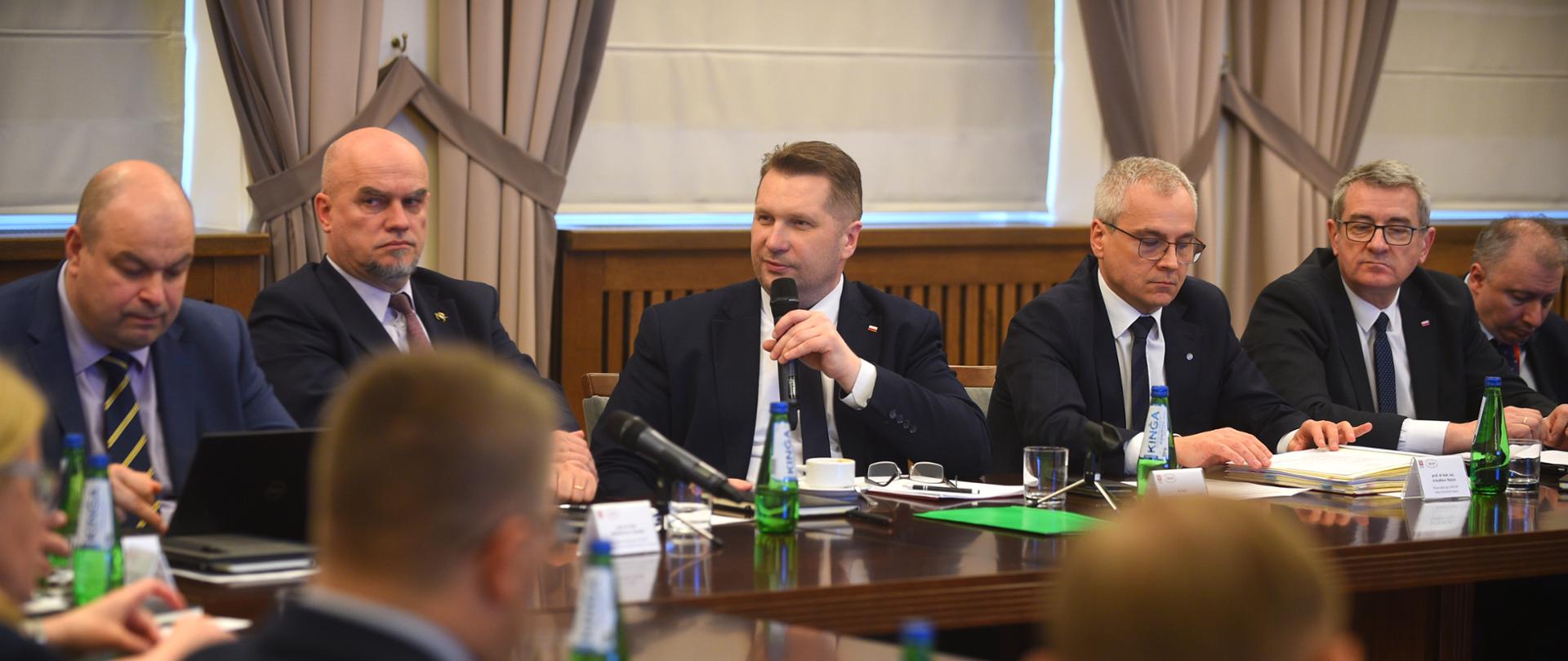 Spotkanie KRASP wraz z udziałem ministra Czarnka. Minister przemawia do mikrofonu, z prawej i lewej stronie ministra widać innych członków spotkania