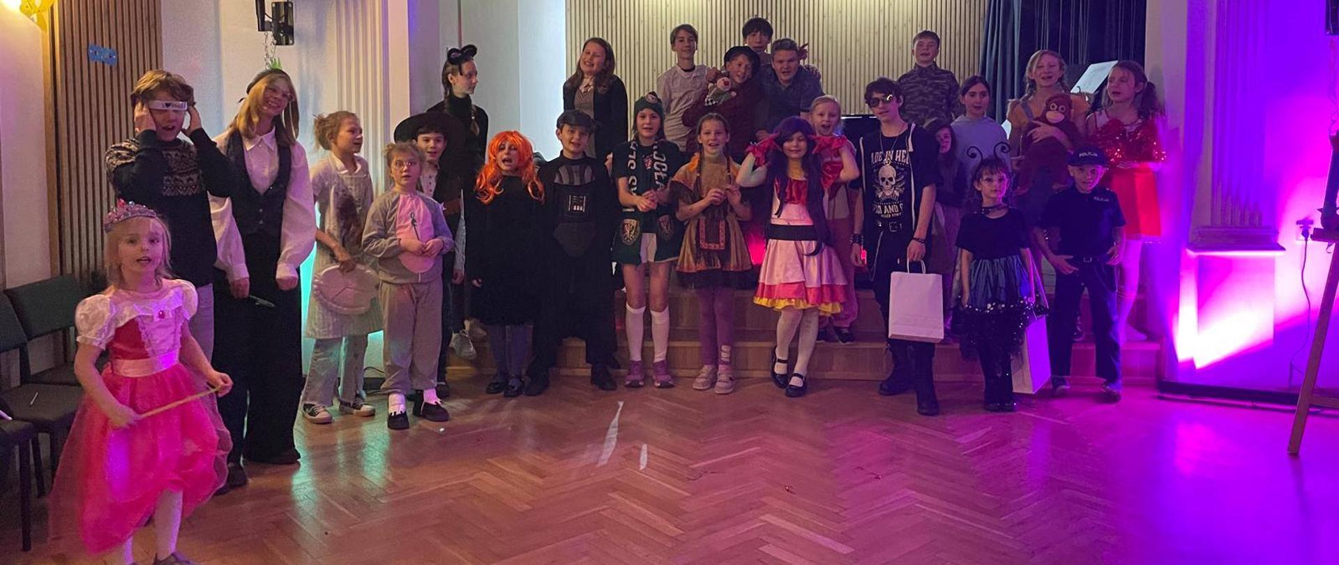 Galeria 18 zdjęć z zabawy karnawałowej, która odbyła się 28 stycznia 2026 r. w auli PSM w Kłodzku, uczniowie bawią się tańcząc w sali koncertowej. 