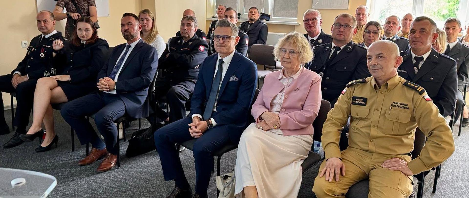Zdjęcie przedstawia zebranych uczestników uroczystości przekazania umów na dofinansowanie w sali komendy powiatowej w Obornikach