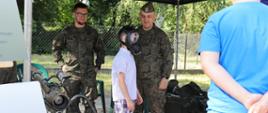 kilkunastoletni chłopiec przymierza maskę gazową od żołnierzy