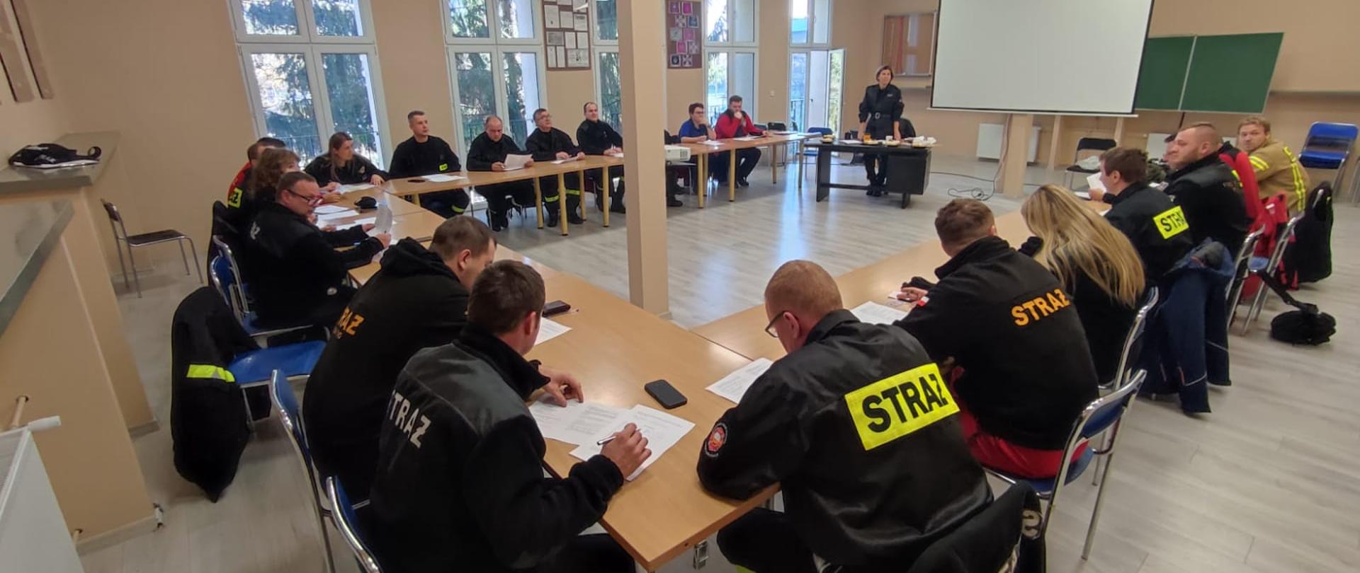Strażacy ratownicy OSP na sali wykładowej podczas pisania testu wiedzy 