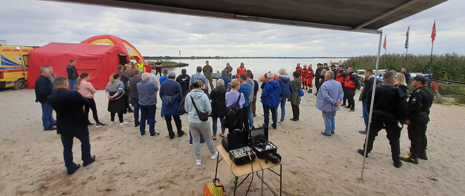 Odprawa - uczestnicy zgromadzeni wokół kierownika ćwiczeń omawiającego założenia.