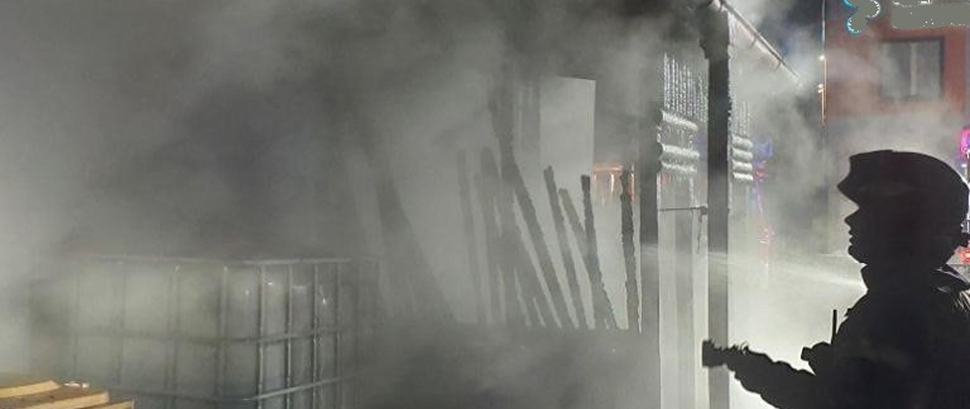 Strażak podczas gaszenia pożaru altanki