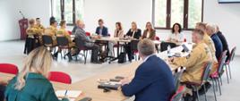 Na zdjęciu widnieją osoby w pomieszczeniu - Burmistrzowie i Wójtowie wraz ze strażakami w sprawie wspólnego spotkania o tematyce OliOC. 