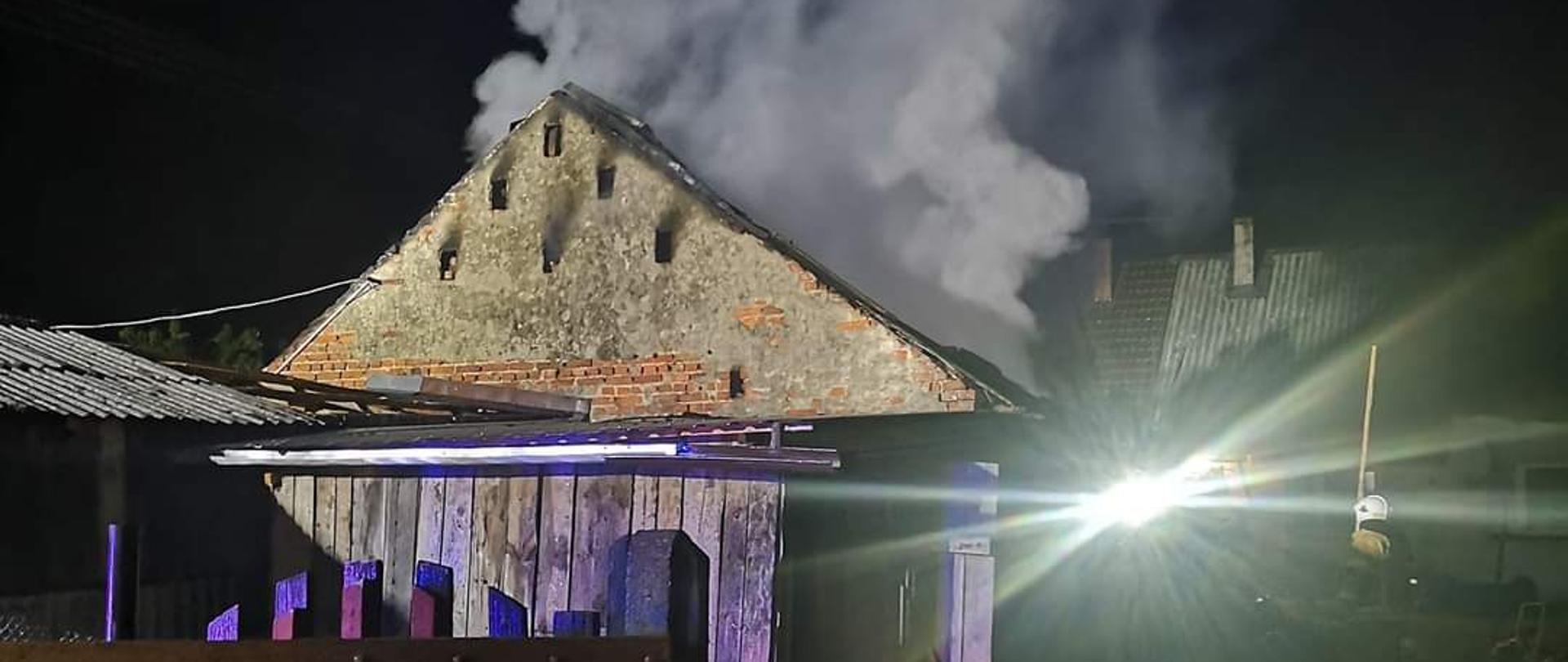 zdjęcie przedstawia pożar budynku gospodarczego w Rąbinku. Z budynku unosi sie para wodna przed budynkiem znajdują sie węże strażackie.