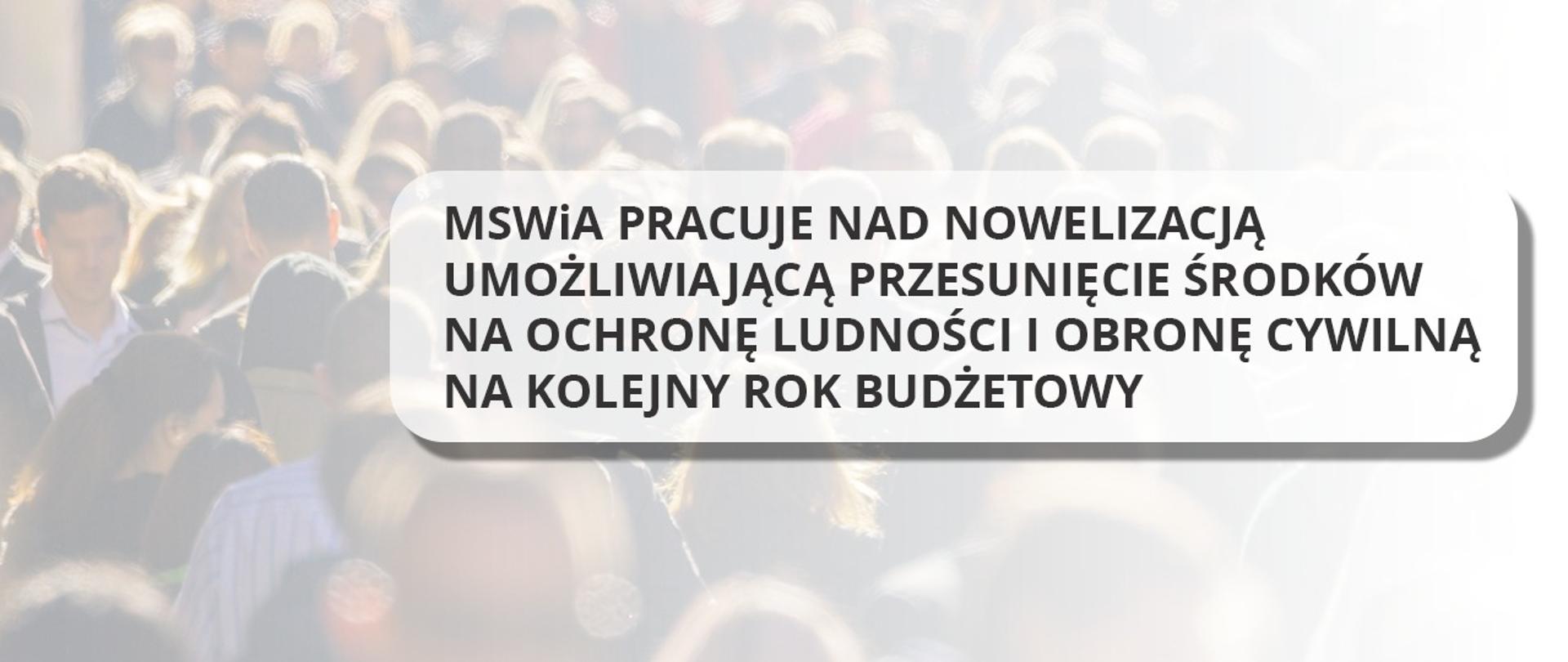 Napis nałożony na rozmazane zdjęcie tłumu o treści: MSWiA pracuje nad nowelizacją umożliwiającą przesunięcie środków na ochronę ludności i obronę cywilną na kolejny rok budżetowy