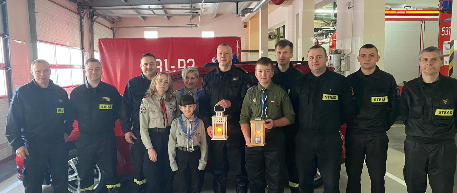 Na garażu JRG w Sztumie stoją Komendant ze zmianą pełniącą służbę w towarzystwie harcerzy.