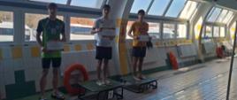 Widoczne podium ze zwycięzcami zrobione na pływalni.