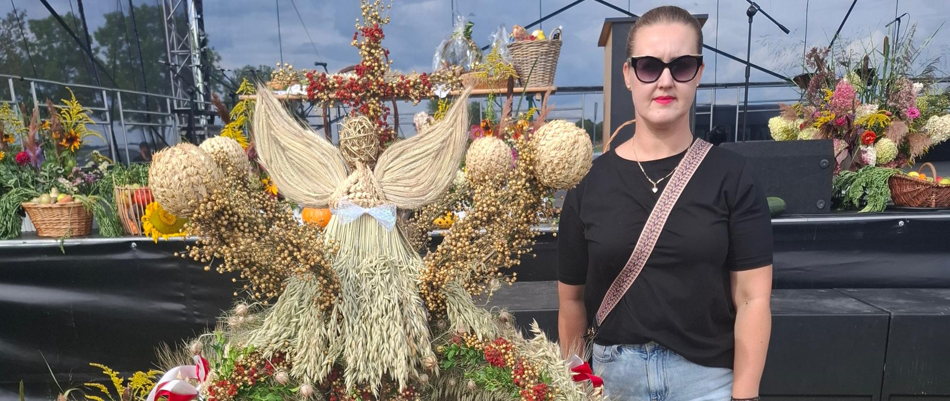 Inspektor stojący przy wieńcu dożynkowym