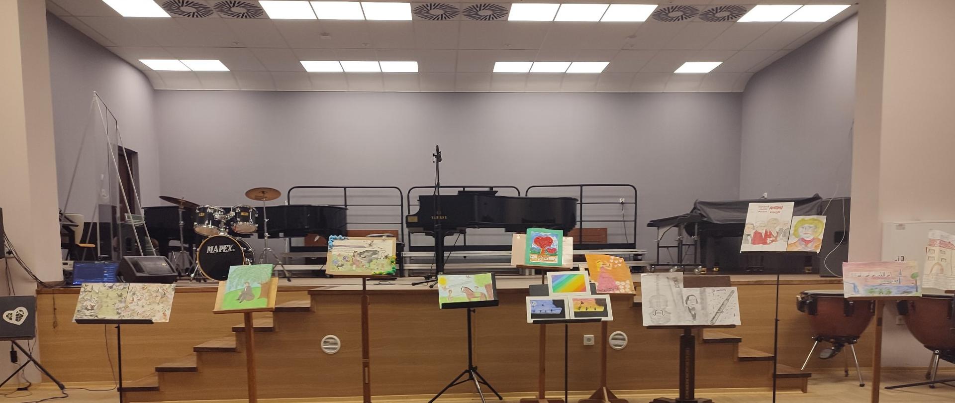 Zdjęcie przedstawia prace plastyczne uczestników konkursu “Echo z dna serca woła mi…”. Na pierwszym planie stolik z nagrodami dla laureatów.