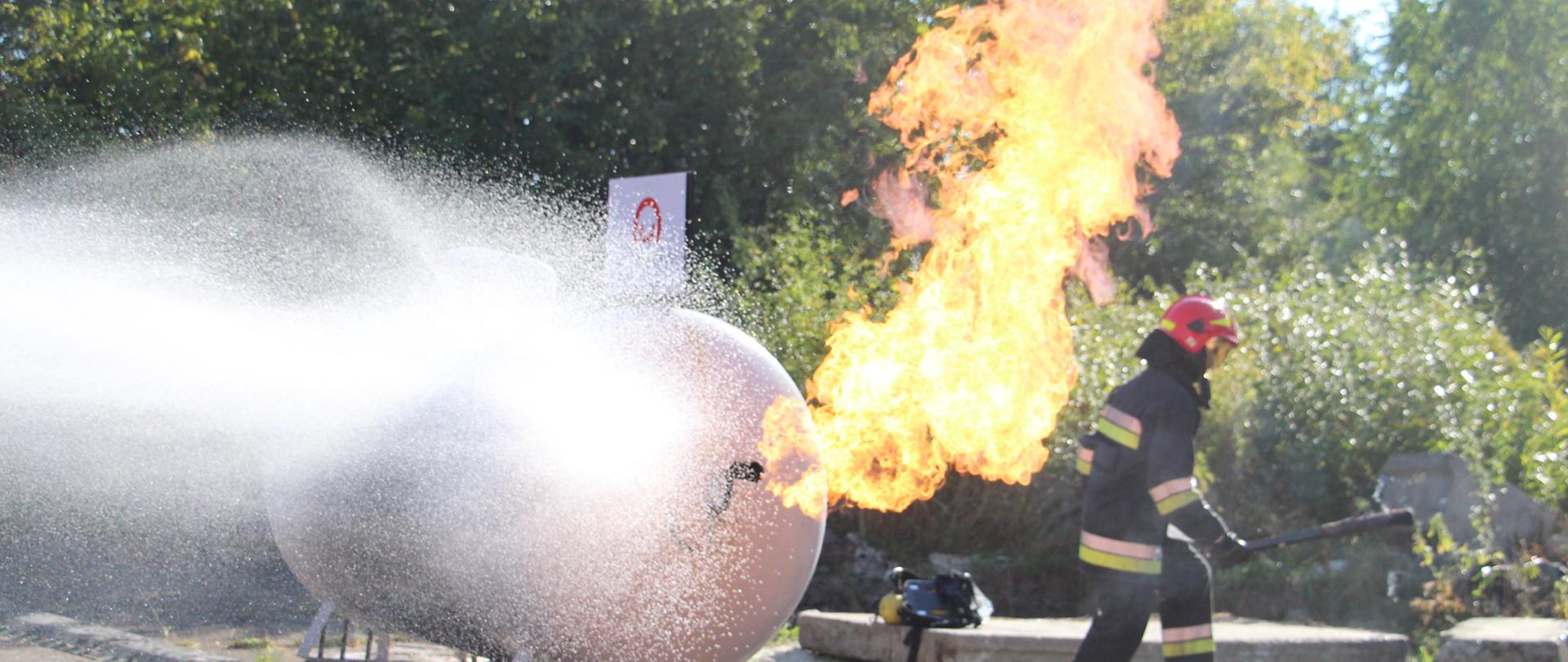 a burning tank put out by water - exercises by Ukrainian rescuers 