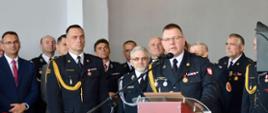 Przy mównicy Zastępca Komendanta Wojewódzkiego PSP w Łodzi w umundurowaniu galowym w tle zgromadzeni goście.