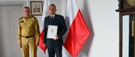 Pomorski komendant wojewódzki PSP stoi z wyróżnionym strażakiem Państwowej Straży Pożarnej.