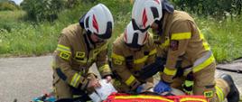 Na zdjęciu trzech strażaków podczas ćwiczeń - reanimacja osoby poszkodowanej