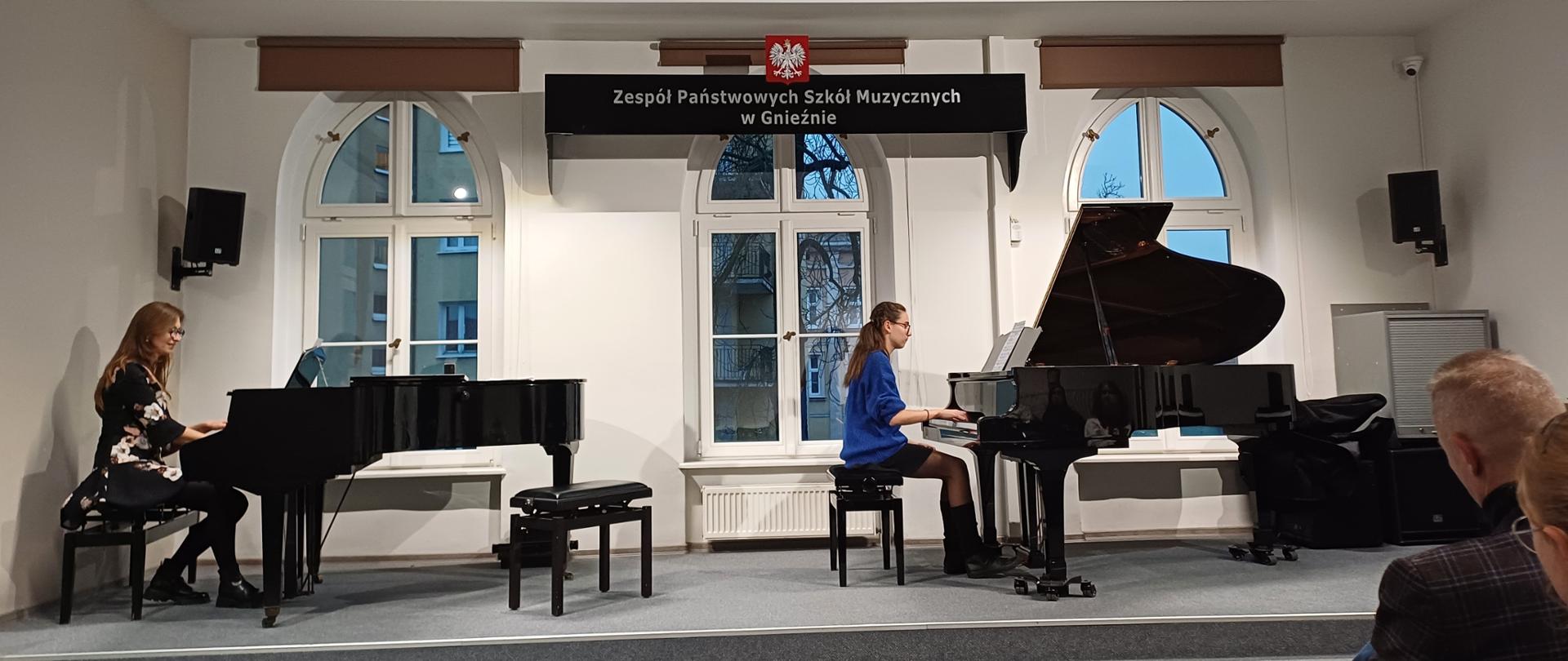 Na scenie prowadząca warsztaty oraz uczennica przy dwóch fortepianach.