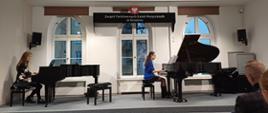 Na scenie prowadząca warsztaty oraz uczennica przy dwóch fortepianach.