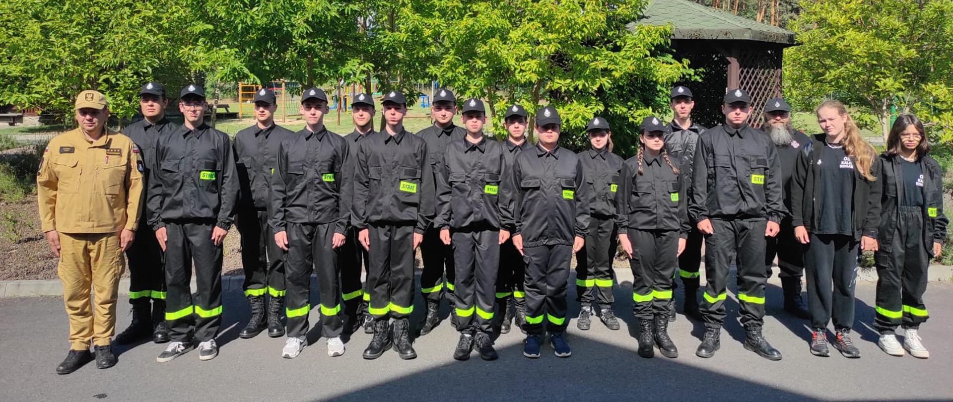 Uczestnicy obozu, osoby umundurowane kostka brukowa, słonecznie, roślinność