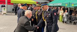 „Wyróżnieni strażacy OSP po zakończonej ceremonii wręczenia odznaczeń i awansów, ustawieni w rzędzie na placu apelowym” - gratulujący Komendant Wojewódzki PSP nadbryg. Artur Gonera, Komendant Powiatowy PSP w Węgrowie bryg. Mateusz Bieniak.