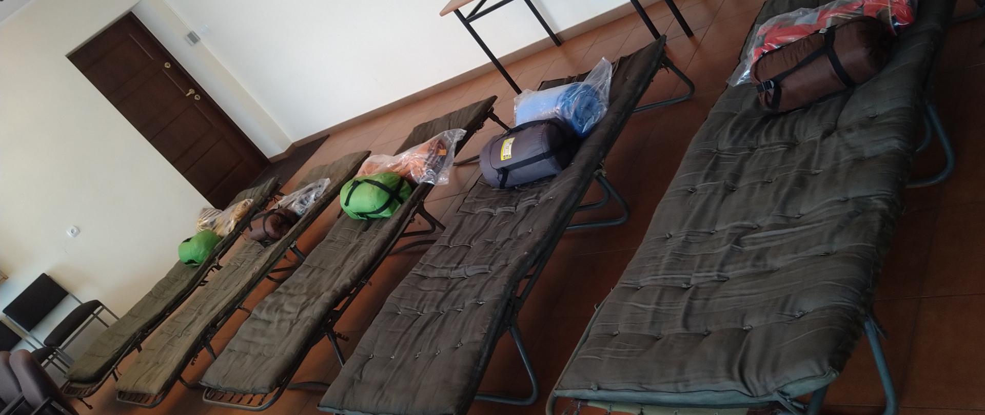 Na zdjęciu widać wnętrze remizy OSP z łózkami i wyposażeniem podstawowym dla przybyszów z Ukrainy 